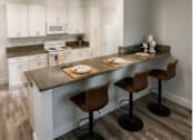 Thumbnail 44 of 56 - A kitchen with a bar and stools.