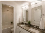 Thumbnail 45 of 56 - A white bathroom with a toilet, sink, and mirror.