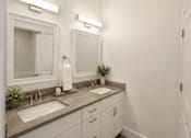 Thumbnail 38 of 56 - A bathroom with two sinks and a large mirror.