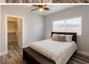 Thumbnail 41 of 56 - A bedroom with a bed, a ceiling fan, and a window with blinds.