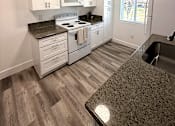 Thumbnail 23 of 56 - A kitchen with white cabinets and a granite counter.