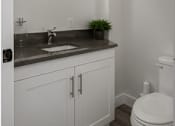 Thumbnail 50 of 56 - A white toilet sits next to a sink in a bathroom.