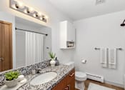 Thumbnail 19 of 20 - A bathroom with a white toilet, a sink, and a mirror.
