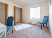 Thumbnail 26 of 33 - A room with a white table, two blue chairs, and a white rug.