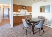 Thumbnail 5 of 33 - A dining room with a table and chairs.