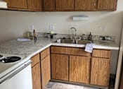 Thumbnail 9 of 10 - a kitchen with white appliances and wooden cabinets