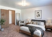 Thumbnail 4 of 11 - A bedroom with a large bed and a chair.