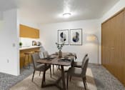 Thumbnail 3 of 11 - A dining room with a table set for two and a kitchen area in the background.