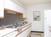 Thumbnail 4 of 11 - A kitchen with white cabinets and a fridge.