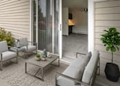 Thumbnail 8 of 11 - A patio with a table, chairs, and potted plants.