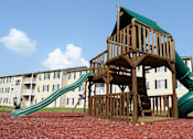 Thumbnail 10 of 11 - A wooden playground structure with a green slide.