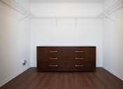 Thumbnail 8 of 13 - A brown dresser is in a white room with a white ceiling and a white wall.