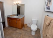 Thumbnail 10 of 13 - A bathroom with a toilet, a cabinet, and a mirror.