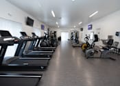 Thumbnail 11 of 13 - A gym with treadmills and exercise bikes.