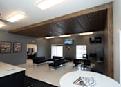 Thumbnail 13 of 13 - A modern living room with a black couch and a television.
