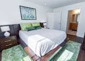 Thumbnail 7 of 14 - A bedroom with a large bed and a painting on the wall.