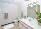 Thumbnail 8 of 17 - A white toilet sits next to a sink in a bathroom.