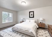 Thumbnail 10 of 14 - A bedroom with a large bed, two nightstands, and a framed picture on the wall.