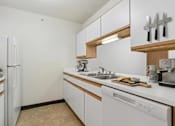 Thumbnail 3 of 10 - A kitchen with white appliances and wooden accents.