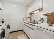 Thumbnail 4 of 10 - A kitchen with white appliances and wooden cabinets.