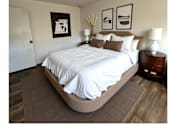 Thumbnail 2 of 4 - A bedroom with a large bed and two framed pictures on the wall.