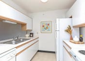 Thumbnail 10 of 14 - A kitchen with white cabinets and a painting on the wall.