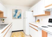Thumbnail 3 of 14 - A kitchen with white cabinets and a white fridge.
