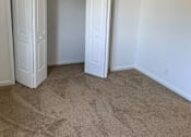Thumbnail 6 of 9 - a bedroom with a carpeted floor and two doors