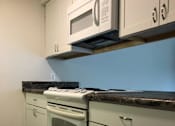 Thumbnail 13 of 15 - a kitchen with white cabinets and a white stove top oven