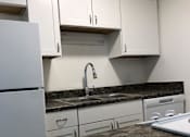 Thumbnail 15 of 15 - a kitchen with white cabinets and a granite counter top