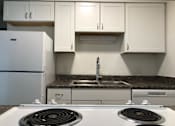 Thumbnail 12 of 15 - a kitchen with a stove top oven next to a refrigerator