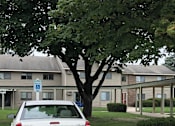 Thumbnail 1 of 12 - a white car parked in front of an apartment building