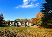 Thumbnail 3 of 15 - a house with a carport and a lawn in front of it