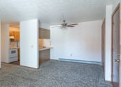 Thumbnail 4 of 8 - an empty living room and kitchen with a ceiling fan