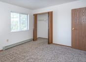 Thumbnail 1 of 8 - an empty bedroom with a closet and a window