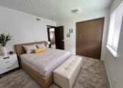 Thumbnail 8 of 13 - A bedroom with a large bed and a white dresser.