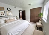 Thumbnail 7 of 13 - A bedroom with a large bed and a brown wardrobe.