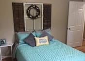 Thumbnail 11 of 12 - a bedroom with a bed and a wreath on the wall