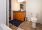 Thumbnail 12 of 17 - A bathroom with a toilet, a mirror, and a cabinet.
