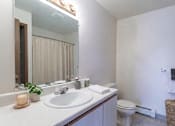 Thumbnail 7 of 11 - A bathroom with a white sink and toilet.