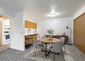 Thumbnail 3 of 11 - A dining room with a round table and grey chairs.