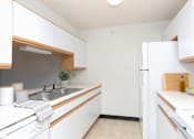 Thumbnail 8 of 11 - A kitchen with white cabinets and a white fridge.