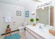 Thumbnail 13 of 13 - A bathroom with a white toilet, sink, and a mirror.