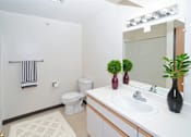 Thumbnail 12 of 13 - A bathroom with a toilet, sink, and mirror.
