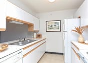 Thumbnail 3 of 13 - A kitchen with white cabinets and a fridge.