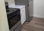 Thumbnail 5 of 8 - A kitchen with a stove, oven, microwave, and refrigerator.