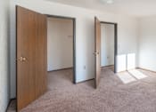 Thumbnail 3 of 5 - an empty bedroom with three doors and carpeting