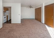 Thumbnail 4 of 5 - an empty living room with a ceiling fan and a kitchen