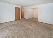 Thumbnail 3 of 11 - an empty living room with carpet and a door to a bedroom
