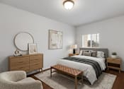 Thumbnail 4 of 9 - A bedroom with a bed, nightstand, and chair.